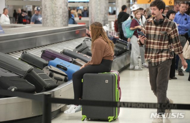 27일(현지시간) 미 콜로라도주 덴버 국제공항 사우스웨스트 항공의 수하물 찾는 곳에서 한 여행객이 가방에 
걸터앉아 또 다른 가방이 나오길 기다리고 있다. 타 항공사와 달리 사우스웨스트 항공의 대규모 결항이 계속되면서 항공대란이 이어지자
 미 교통 당국이 조사에 나섰다. 2022.12.28. 덴버=AP/뉴시스