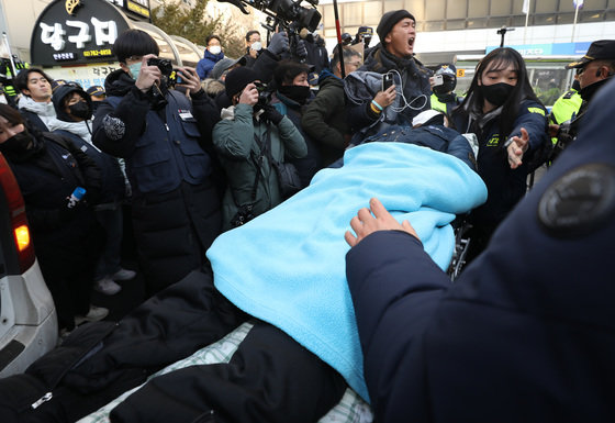 유최안 금속노조 거제통영고성 조선하청지회 부지회장이 27일 오후 서울 여의도 더불어민주당 중앙당사에서 ‘노란봉투법’으로 불리는 노동조합 및 노동관계조정법(노조법) 2·3조 개정을 촉구하며 점거 농성을 벌이던 도중 쓰러져 들것에 실려 나오고 있다. 2022.12.27/뉴스1