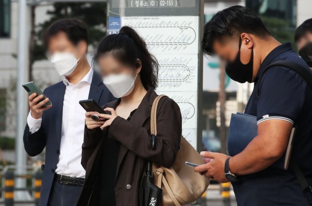 서울 시내 한 버스정류장에서 시민들이 스마트폰을 하고 있다. 2021.10.05. 뉴시스