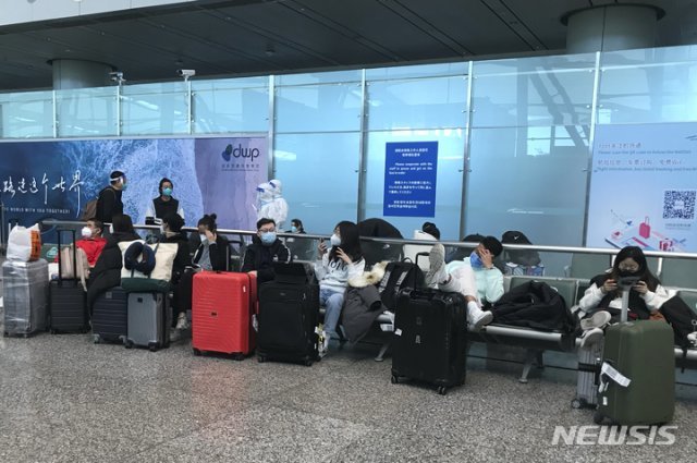 지난 25일 중국 광둥성 광저우의 바이윈 공항에서 입국자들이 검역 호텔과 시설로 가는 버스에 탑승하기 위해 몇 시간째 기다리고 있다. 중국 정부는 코로나19 확산을 막기 위해 시행하던 입국자 강제 격리 조치를 내달 8일부터 철폐한다고 발표했다. 2022.12.27 광저우=AP/뉴시스