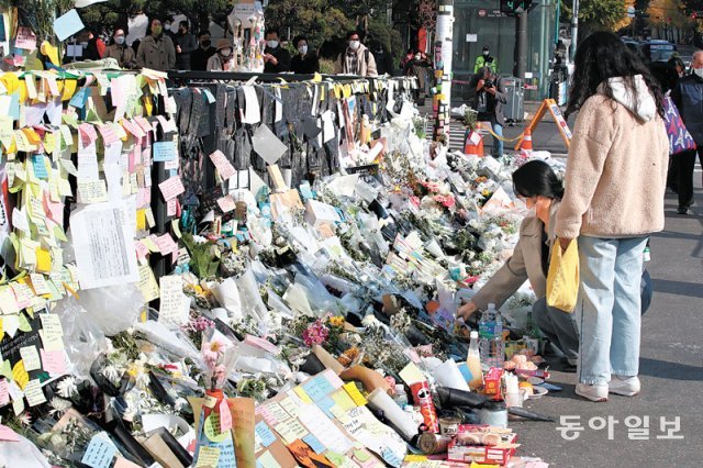 “기억할게요” 이태원역 덮은 추모 메시지 지난달 7일 서울 용산구 지하철 6호선 이태원역 앞에 마련된 이태원 핼러윈 
참사 희생자 추모공간에 한 시민이 조화를 놓고 있다. 참사 전 ‘압사가 우려된다’는 112 신고 등이 있었음에도 사고를 막지 못한
 경찰과 용산구, 소방당국 등에 대한 책임론이 거세게 불거졌고 이는 경찰 수사와 국회 국정조사로 이어졌다. 전영한 기자 
scoopjyh@donga.com