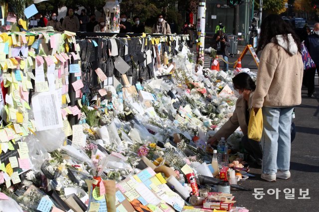 지난달 서울 용산구 지하철 6호선 이태원역 앞에 마련된 이태원 핼러윈 참사 희생자 추모공간에 한 시민이 조화를 놓고 있다. 전영한 기자 scoopjyh@donga.com