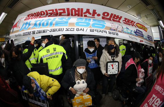 전국장애인차별철폐연대(전장연) 회원들이 2일 오전 서울 삼각지역에서 장애인 권리 예산 확보를 위한 지하철 타기 선전전에 나섰으나 승차를 저지당하고 있다. 전장연은 이날 오전 9시 31분께 기자회견을 마친 뒤 시위를 위해 열차에 탑승하려고 했으나 서울교통공사에 막혀 승차를 저지당한 뒤 현재 대치 중이다. 2023.1.2. 뉴스1