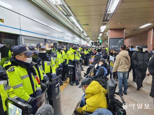 2일 오전 서울 용산구 지하철 4호선 삼각지역에서 열차에 탑승하려는 전국장애인차별철폐연대 활동가들을 경찰이 막아서고 있다. 이문수 기자 doorwater@donga.com