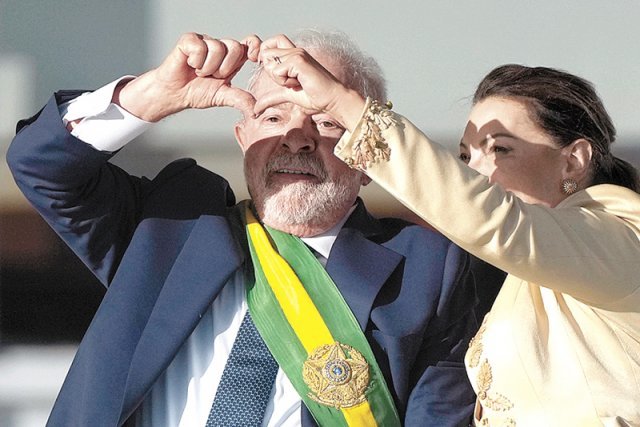3번째 임기를 시작한 루이스 이나시우 룰라 다시우바 브라질 대통령(왼쪽)이 1일(현지 시간) 취임식에서 부인 호잔젤라 여사와 손으로 하트를 그리며 지지층의 환호에 답하고 있다. 브라질리아=AP 뉴시스