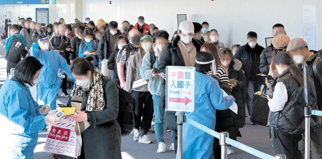 2일 인천국제공항 제1여객터미널 입국장에서 공항 관계자들이 중국에서 입국한 승객들을 분류하고 있다. 
방역 당국은 이날부터 중국에서 항공편이나 배편을 통해 입국한 전원에 대해 신종 코로나바이러스 감염증(코로나19) 
유전자증폭(PCR) 검사를 실시하는 등 고강도 방역 대책을 실시했다. 인천=공항사진기자단