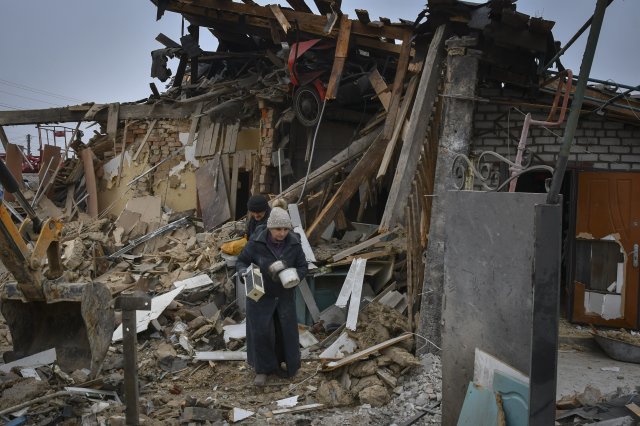 1일(현지시간) 우크라이나 자포리자 주민들이 러시아군의 로켓 공격으로 폐허가 된 집을 나서면서 식기 등 소지품을 챙기고 있다. 2023.01.02. AP/뉴시스