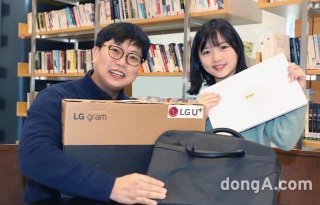 LG유플러스 임직원이 초등학교 입학을 앞둔 아동과 선물 받은 노트북을 소개하는 모습. LG유플러스 제공
