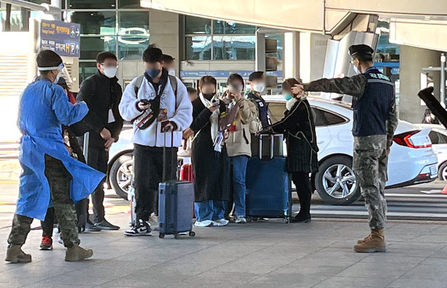 인천국제공항 제1여객터미널에서 공항 의료진 및 군 관계자들이 중국발 입국자들에게 코로나19 검사소 이동을 안내하고 있다. 뉴스1