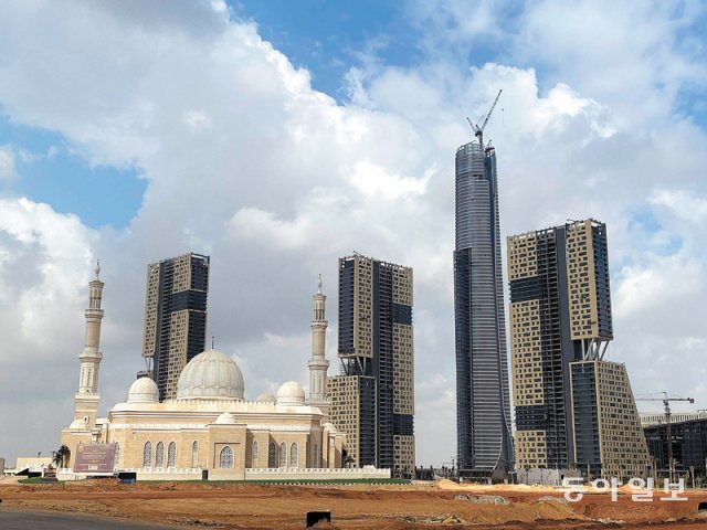 지난해 12월 26일(현지 시간) 이집트 수도 카이로 인근 신행정수도 내 상업지구의 건설 현장 모습. 완공되면 아프리카에서 가장 
높은 건물이 될 오벨리스크 모양의 ‘아이코닉 타워’(오른쪽에서 두 번째) 상층부에서 크레인이 돌아가고 있다. 중국 자본이 대거 
투입됐고 중국 건설사가 공사를 담당하는 이 일대에는 이집트에서 보기 힘든 마천루가 속속 들어설 예정이다. 카이로=강성휘 특파원 
yolo@donga.com