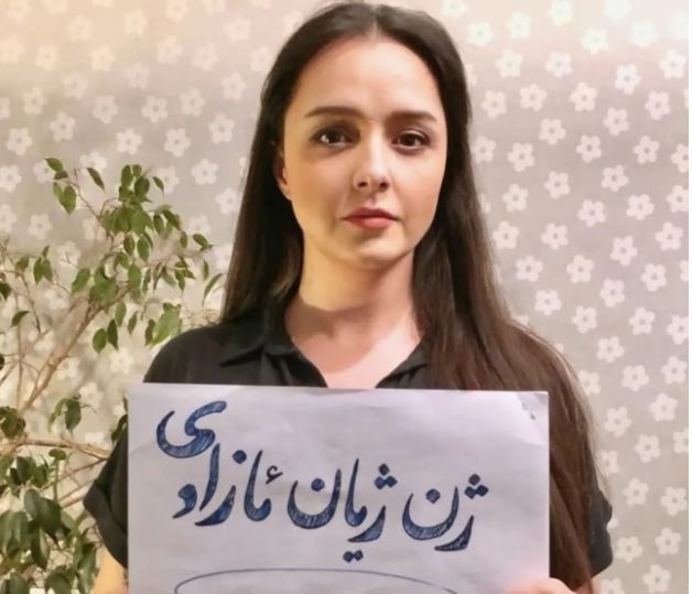 히잡을 벗은 채 이란의 반정부 시위를 요약한 슬로건 ‘여성, 생명, 자유’가 적힌 종이를 든 알라두스티의 모습. 타라네 알라두스티 SNS 갈무리