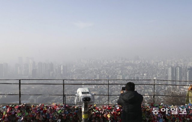 8일 수도권과 대구, 경북, 충청, 강원 영서 등 9개 시도에서 초미세먼지(PM2.5) 비상저감 조치가 시행된 가운데 서울 중구 
남산을 오른 시민이 미세먼지로 뿌옇게 변한 서울 시내를 내려다보고 있다. 국립환경과학원에 따르면 이번 미세먼지는 대기 정체로 인해
 쉽사리 물러나지 않고 이번 주 중반까지 계속될 것으로 보인다. 원대연 기자 yeon72@donga.com