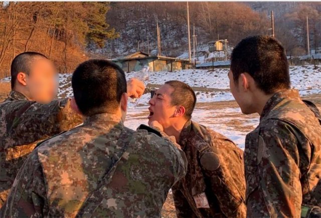 방탄소년단(BTS)의 멤버 진(왼쪽에서 세 번째)이 최근 신병교육대에서 화생방 훈련을 받은 뒤 힘들어하자 동료들이 얼굴에 물을 부어주고 있다. 사진 출처 페이스북