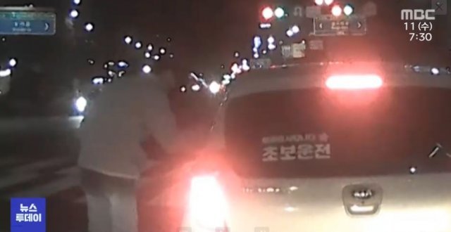 ‘초보 운전’ 스티커를 붙이고 지그재그로 운전하던 A 씨 차량으로 다가가 상황을 살펴보는 시민 B 씨. MBC뉴스 방송화면 캡처