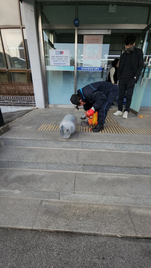 가스통을 절단하는 강영찬 지역사회보장협의체 위원장. 상장동 행정복지센터 제공