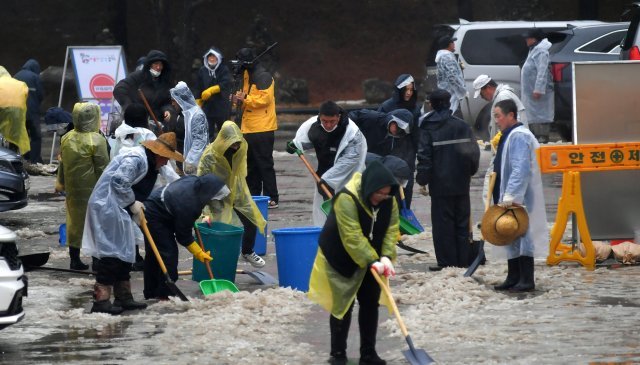 13일 강원 화천군 공무원들이 산천어축제장 출입로에서 빗물과 얼음 제거 작업을 하고 있다. 화천군 제공