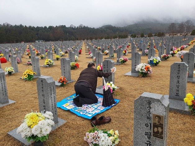 14일 대전 유성구에 있는 국립대전현충원에서 한 성묘객이 묘비를 정성스럽게 닦고 있다.  /뉴스1 ⓒ News1