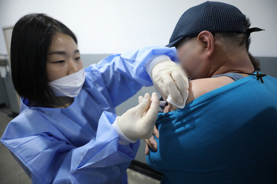 지난 10월18일 오후 서울 중구 봉래동 서울역 다시서기희망지원센터 열린 서울시 노숙인 및 쪽방촌 주민 대상 무료 독감 예방접종 행사에서 의료진이 한 시민에게 독감 백신을 접종하고 있다. 글로벌 헬스케어 기업 사노피는 노숙인 및 쪽방촌 주민 등 주거 취약계층 2,500여명의 건강한 겨울나기를 위해 내년 1월까지 무료 독감 예방접종을 실시한다. 2022.10.18/뉴스1