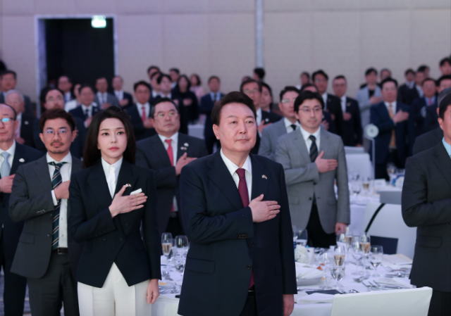 윤석열 대통령과 김건희 여사가 경제인과의 만찬 간담회에서 참석자들과 국기에 대한 경례를 하고 있다. 대통령실 페이스북