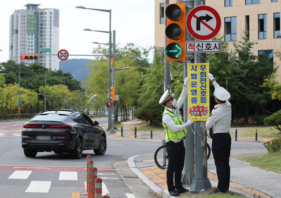 유성경찰서 교통안전계 소속 경찰관들이 22일 대전 유성구 원신흥네거리에서 ‘우회전 신호등’ 시범운영 계도 및 지도를 하고 있다.  2022.9.22 뉴스1