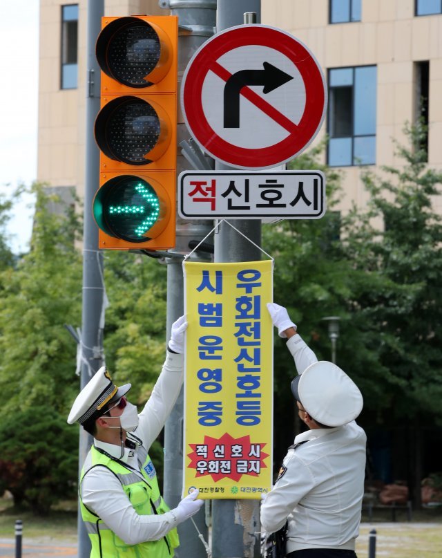 유성경찰서 교통안전계 소속 경찰관들이 지난해 9월 22일 대전 유성구 원신흥네거리에서 ’우회전 신호등’ 시범운영 계도 및 지도를 하고 있다. 뉴스1