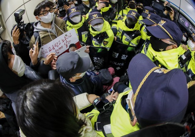 전국장애인차별철폐연대(전장연) 활동가들이 3일 오전 서울 동대문역사공원역에서 홍보물 부착하던 중 경찰들에게 제지를 받고 있다. 전장연은 이날 오전 8시 성신여대역에서 기습 선전전을 진행했다. 뉴스1