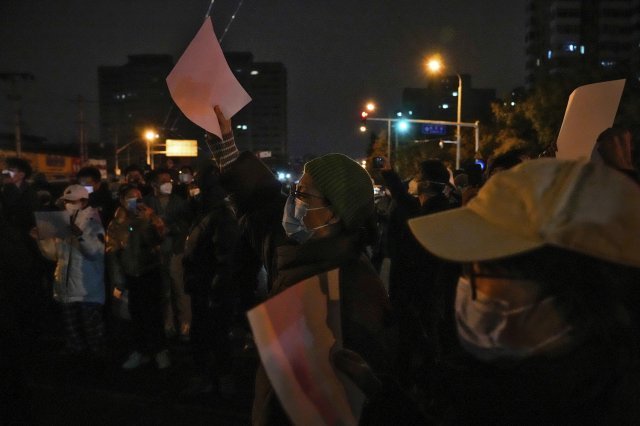 27일 중국 베이징에서 코로나19 봉쇄 정책에 항의하는 시위대가 ‘백지’를 들고 구호를 외치고 있다. 시민들은 정부에 항의하는 의미를 담은 ‘백지’를 들고 28일 새벽까지 시위를 이어갔다. 2022.11.28. 베이징=AP/뉴시스