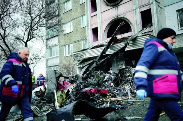 18일 우크라이나 수도 키이우 외곽에 있는 브로바리에서 우크라이나 내무장관 등 고위 관료들이 탄 헬기가 유치원 건물로 추락해 
내무장관, 국무장관 등 각료와 유치원 어린이 4명 등 최소 17명이 숨졌다. 구조대원들 사이로 시커멓게 불에 탄 헬기 잔해가 
보인다. 브로바리=AP 뉴시스