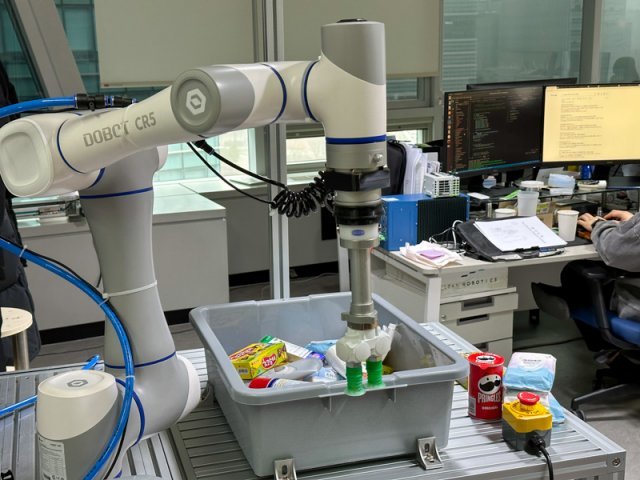 플라잎 사무실에 마련된 테스트용 로봇이 상자에서 원하는 제품만 선별해 집어 드는 ‘피스피킹(Piece Picking)’ 기술을 시연하고 있다. 출처=IT동아