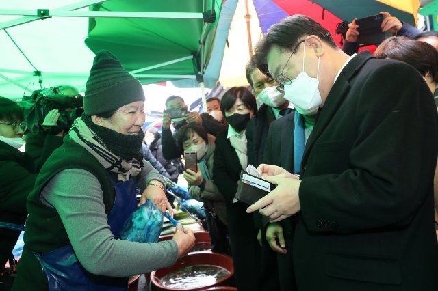더불어민주당 이재명 대표가 지난달 28일 광주 광산구 송정 5일 시장을 방문해 상인들과 인사를 나누던 중 낙지를 구매하고 있다. 뉴스1