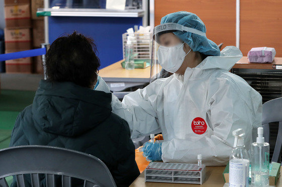 18일 오전 서울 동대문구보건소에 마련된 신종 코로나 바이러스 감염증(코로나19) 선별진료소에서 한 시민이 PCR검사를 받고 있다. 2023.1.18/뉴스1