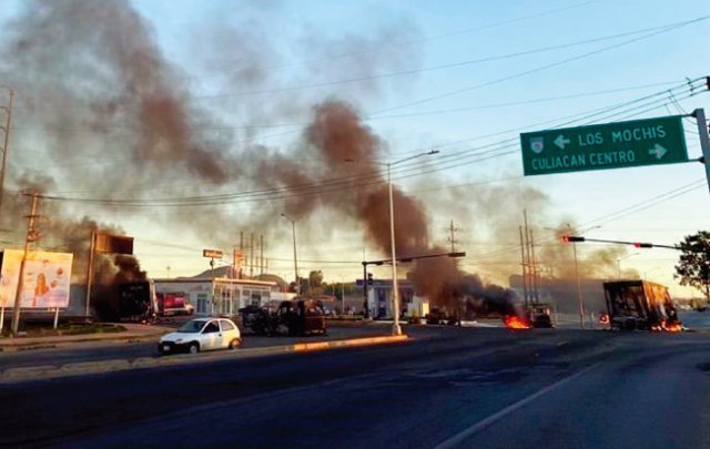 A truck is set on fire during a street battle between the Mexican National Guard and members of the Sinaloa Cartel. [REFORMA]