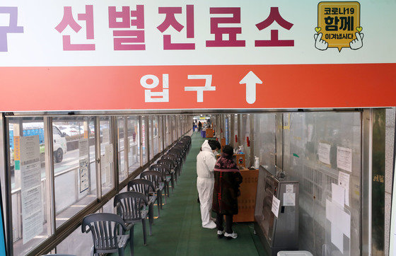 서울 동대문구보건소에 마련된 신종 코로나 바이러스 감염증(코로나19) 선별진료소에서 의료진이 시민에게 검사를 안내하고 있다./뉴스1
