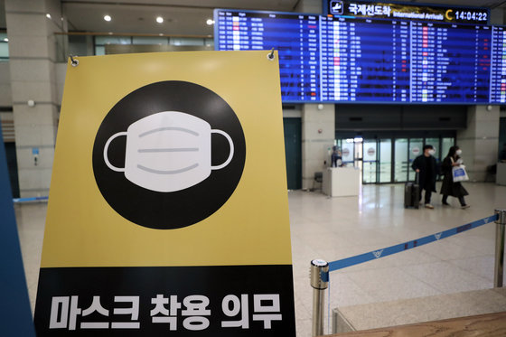 정부가 실내 마스크 착용 의무 해제 결정을 발표한 20일 인천국제공항 입국장에서 ‘마스크 착용 의무’ 안내문이 설치돼 있다. 이날 정부는 오는 30일부터 실내 마스크 착용 ‘의무’를 ‘권고’로 변경한다고 밝혔다. 대중교통이나 병원, 요양시설 등은 기존대로 실내마스크 착용 의무가 유지된다. 2023.1.20/뉴스1