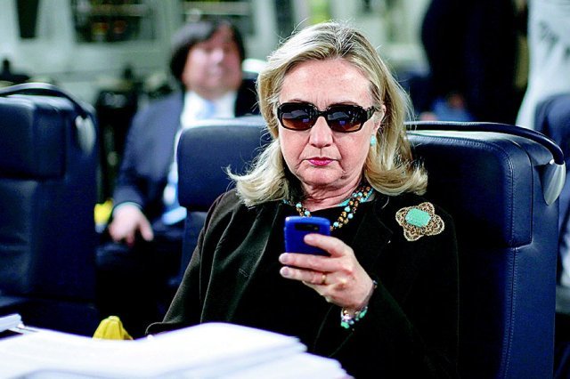 2011년 8월 힐러리 클린턴 당시 미국 국무장관이 미 군용기 안에서 자신의 블랙베리 휴대전화를 들여다보고 있다. 워싱턴=AP 뉴시스
