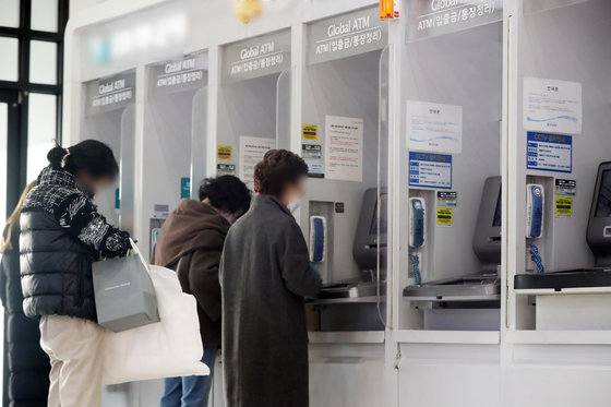 사진은 27일 서울 시내 한 건물에 설치된 은행의 현금인출기(ATM)에서 시민들이 입출금을 하는 모습. 2022.12.27/뉴스1 ⓒ News1