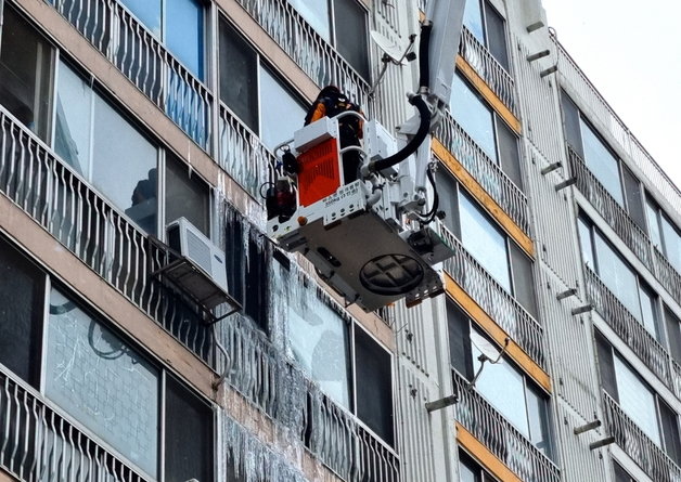 26일 오전 10시30분께 전북 전주시 덕진구 반월동의 한 아파트 단지에 소방대원들이 출동해 굴절차를 타고 아파트 외벽에 생긴 대형 고드름을 제거하는 작업을 벌였다. 전북 전주덕진소방서 제공