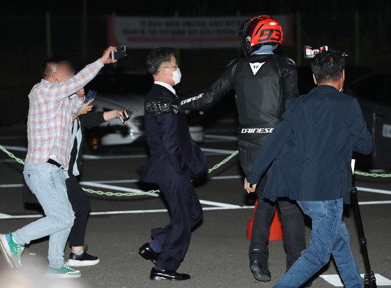 김만배씨가 구속영장 기각으로 서울구치소에서 나온 뒤 바이크 헬멧을 남성의 도움을 받고 있다. 헬멧 쓴 남성이 최우향 화천대유 이사로 추정된다.  2021.10.15/뉴스1 ⓒ News1