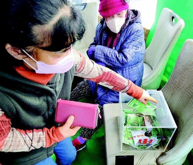 지난해 12월 인천 동구 만석동 쪽방촌 주민들이 모금함에 성금을 넣고 있다. 인천쪽방상담소 제공