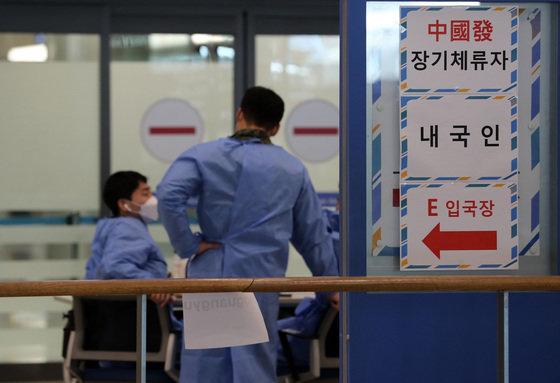 인천국제공항 제1여객터미널 입국장에서 방역 관계자들이 중국발 해외 입국자들을 기다리고 있다./뉴스1