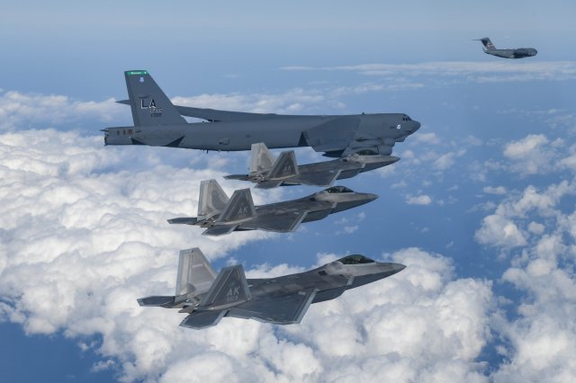 현존하는 세계 최강 전투기로 꼽히는 미국의 F-22 스텔스기(랩터·아래 3대)와 핵 탑재가 가능한 B-52H 전략폭격기(위)가 20일 한반도로 전개됐다.  국방부 제공