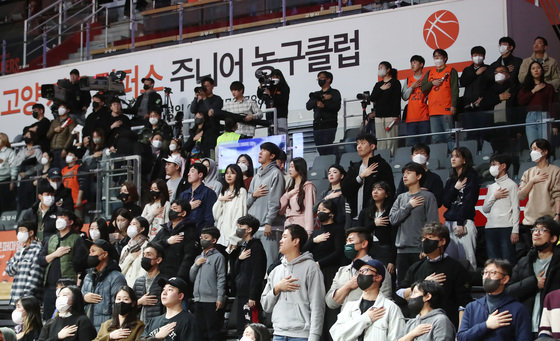 실내 스포츠 경기장 마스크 착용 의무가 권고로 완화된 지난달 30일 오후 경기도 고양시 고양체육관에서 열린 ‘SKT 에이닷 프로농구 2022-2023 KBL’ 고양 캐롯과 서울 삼성의 경기에서 관중들이 국기에 경례하고 있다. 2023.1.30/뉴스1 ⓒ News1