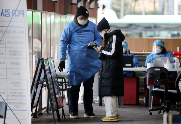 서울 송파구 보건소 선별진료소에서 한 시민이 PCR검사를 받기 위해 접수를 하고 있다./뉴스1 ⓒ News1
