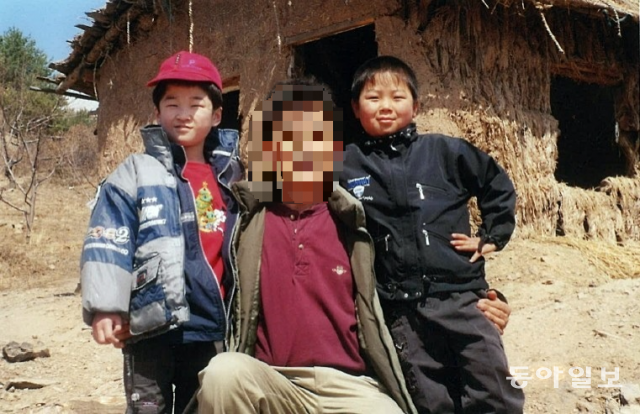 중국에서 유 씨가 거주하던 허름한 흙집. 그 앞에서 유 씨의 아들 유철민(빨간 모자)이 다른 아동과 함께 탈북 고아들을 지원하던 한국인 선교사와 함께 사진을 찍었다.