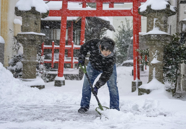 일본에서 올해 들어 가장 추웠던 지난달 25일 일본 돗토리시의 신사 앞에서 주민이 눈을 치우고 있다.  (사진은 기사 내용과 관계없음) AP 교도/뉴시스