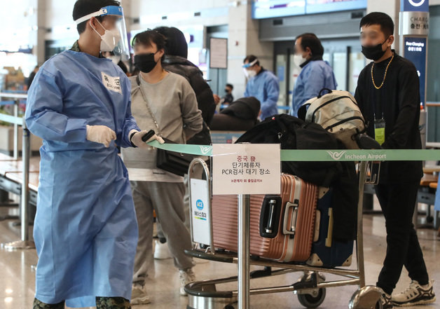 인천공항 제1여객터미널 입국장에서 중국발 입국자들이 코로나19 검사센터로 향하고 있다./뉴스1