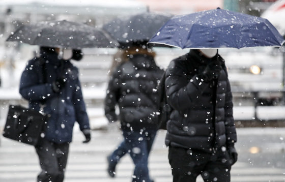 중부지방을 중심으로 많은 눈이 내리고 있는 26일 오전 서울 세종대로사거리에서 우산을 쓴 시민들이 출근길 발걸음을 재촉하고 있다. 2023.1.26/뉴스1