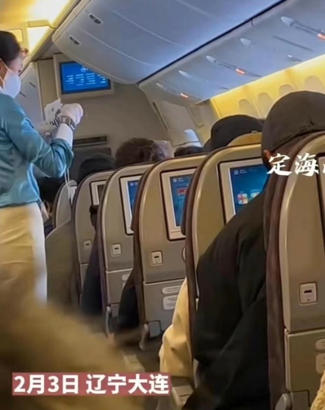 지난 3일 중국 랴오닝성 다롄공항에 착륙하기 전 한 대한항공 여객기에서 승무원이 중국 이외 국적 승객들에게 흰색 비표를 나눠주고 있는 모습. (웨이보 캡처) 뉴시스