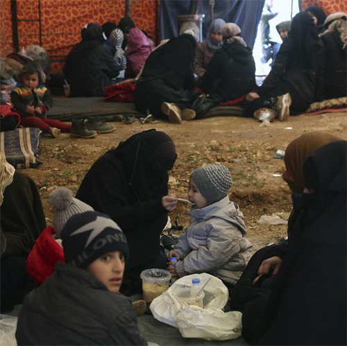 Syrian refugees sheltering from the cold in tents In Idlib, northern Syria, near the southern border of Turkiye on the 8th, victims of the major earthquake shelter from the cold in tents set up by relief organizations on the ground.  A woman is feeding her child relief food.  Idlib = AP Newsis