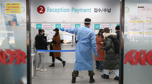 인천공항 제1여객터미널에 마련된 코로나19 검사센터에서 방역 관계자가 중국발 입국자들을 안내하고 있다./뉴스1